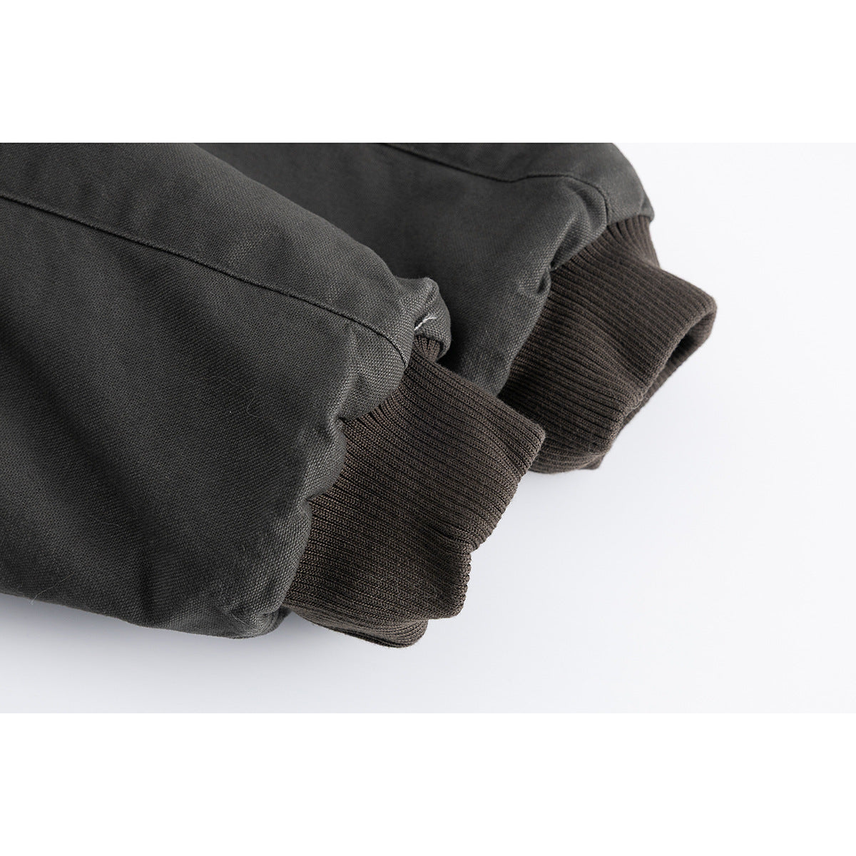 Close-up of the charcoal jacket sleeve and dark rib-knit cuff.