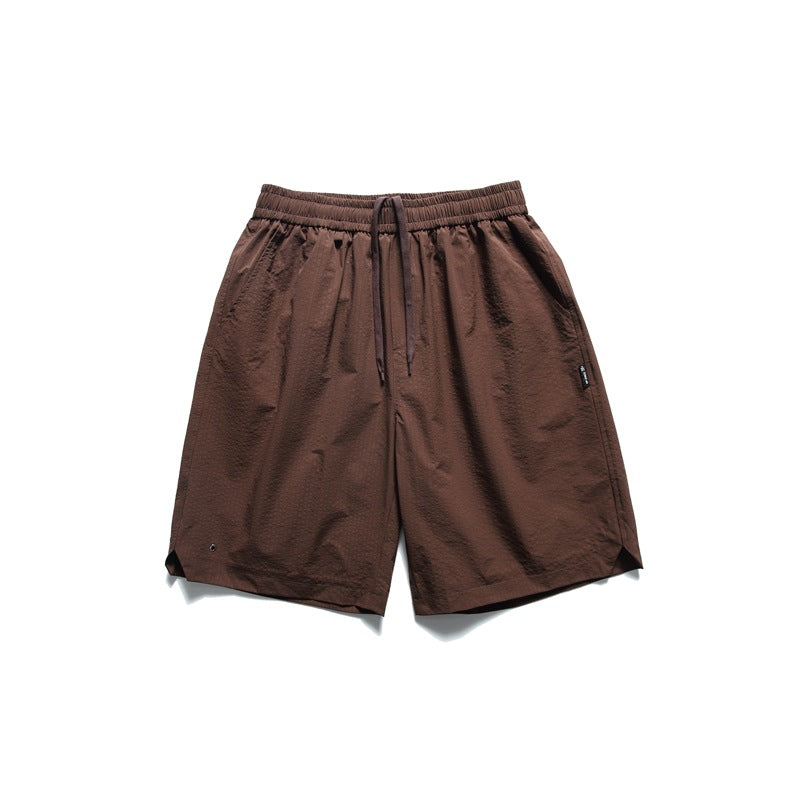 Brown textured knee-length shorts with drawstring elastic waist and notched side hems, flat lay front view