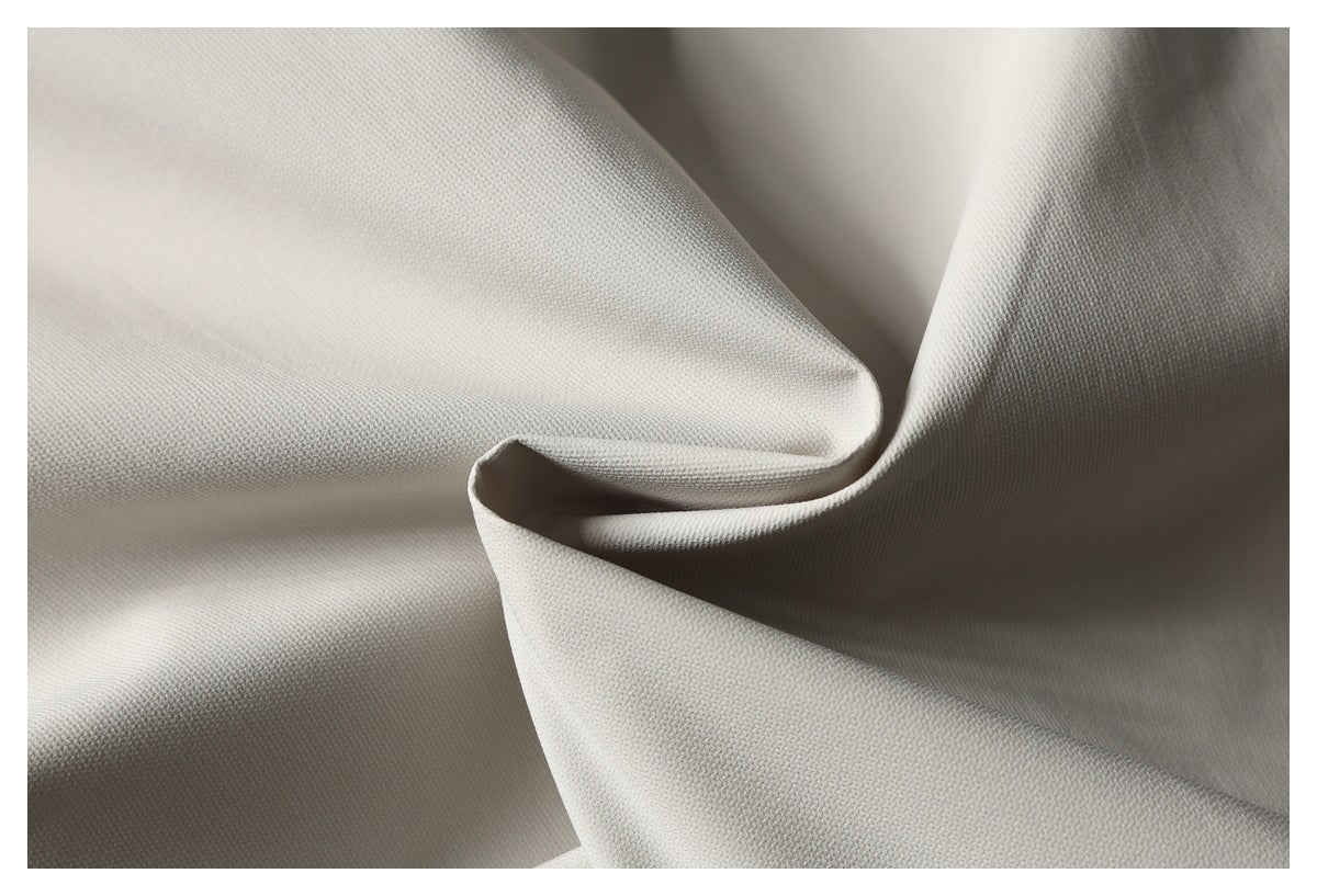 Close-up of pale gray fabric with a fine woven texture arranged in soft folds.