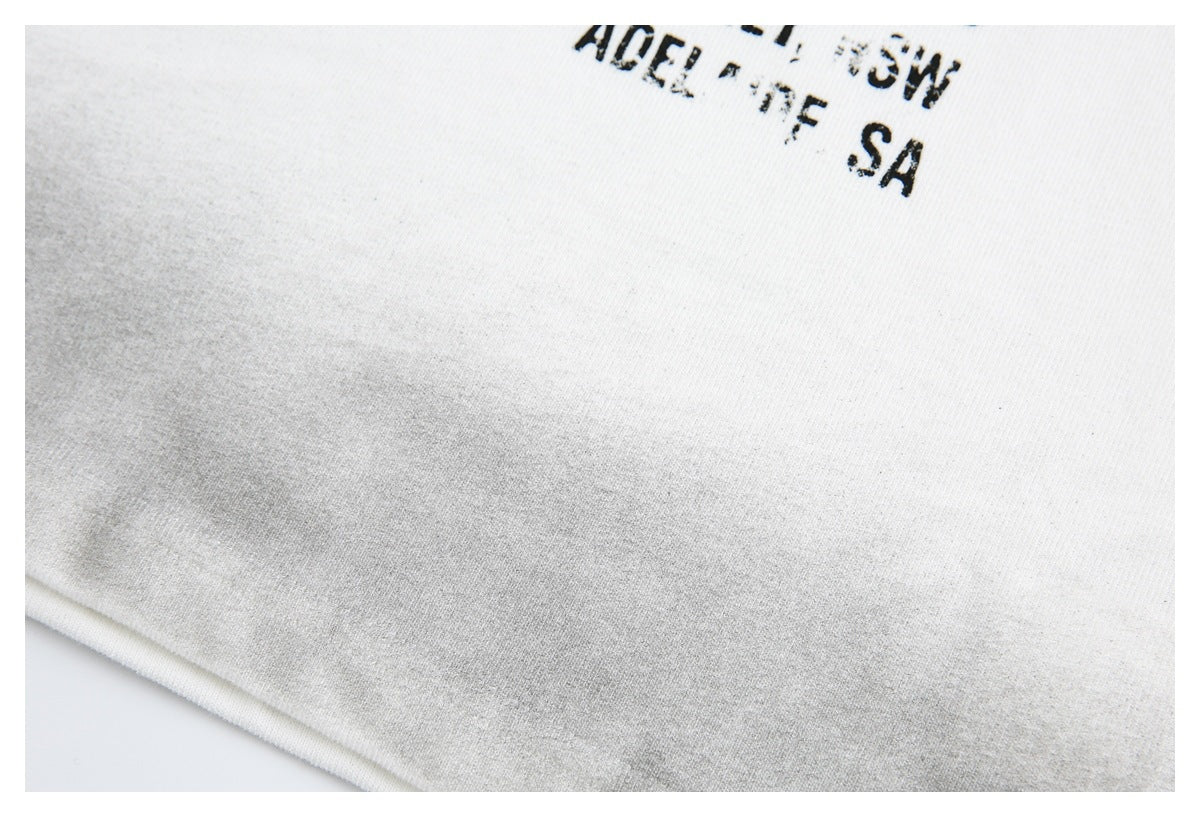 Close-up of an off-white shirt with partial distressed black English lettering at the edge.