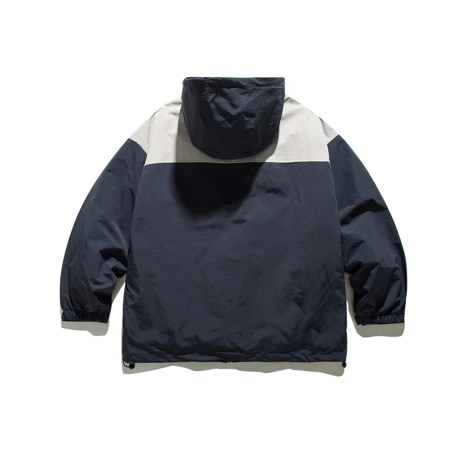Back view of a navy hooded jacket with a light gray shoulder yoke and elastic cuffs.