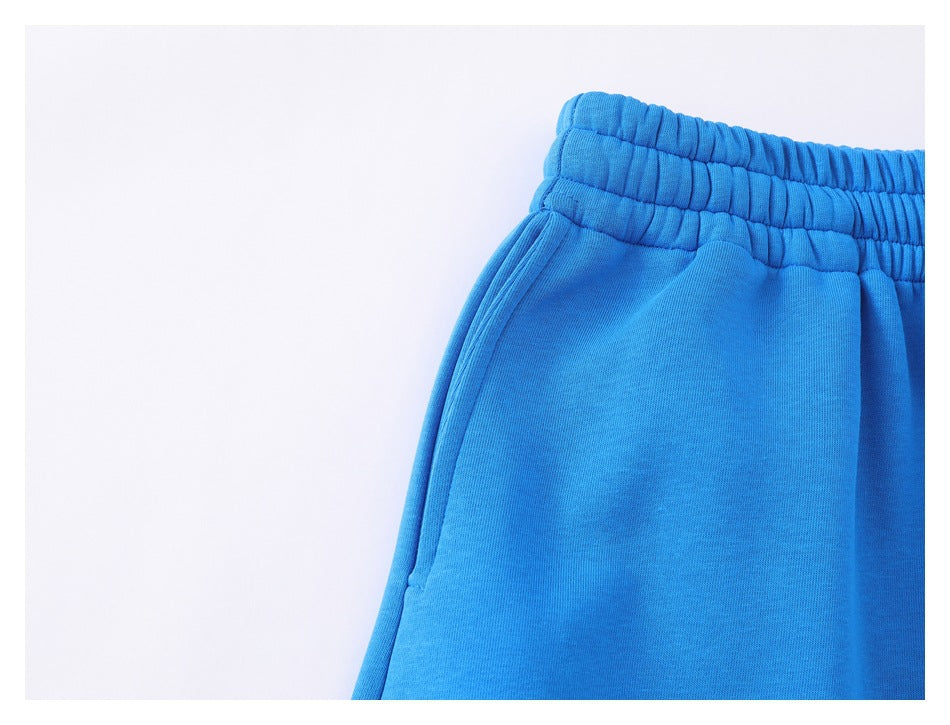 Close-up of bright blue pants showing the elastic waistband and a side pocket opening.