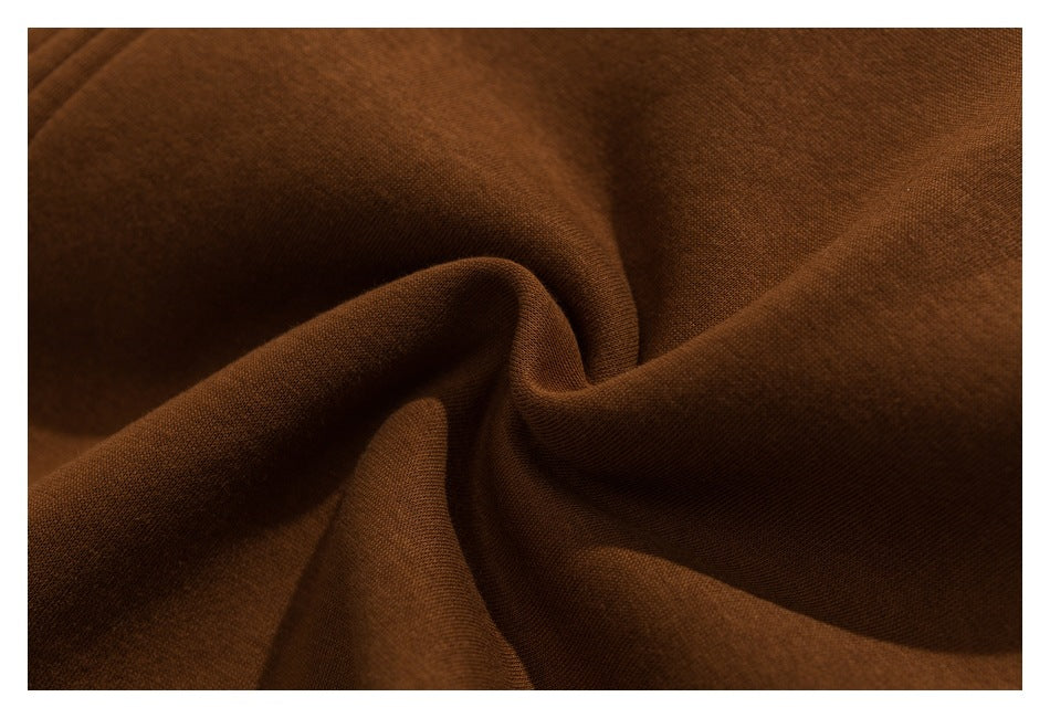 Close-up of smooth dark brown fabric gathered into soft folds, showing its fine surface texture.