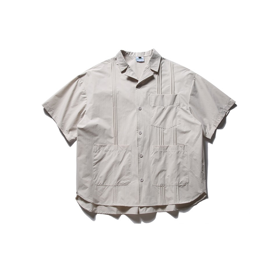 Apricot short-sleeve button-front shirt with three pockets and pintuck detailing, flat lay