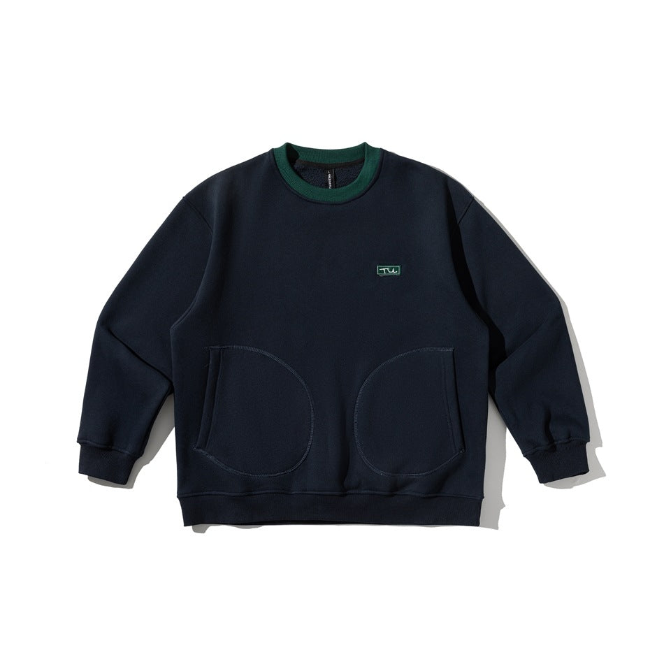 Navy crew-neck sweatshirt flat lay with green ribbed collar, small chest patch and two large rounded front pockets