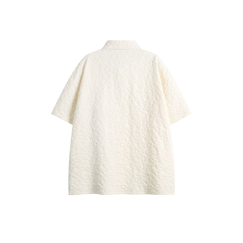 Back view of a white short-sleeve collared shirt with an allover raised floral texture.