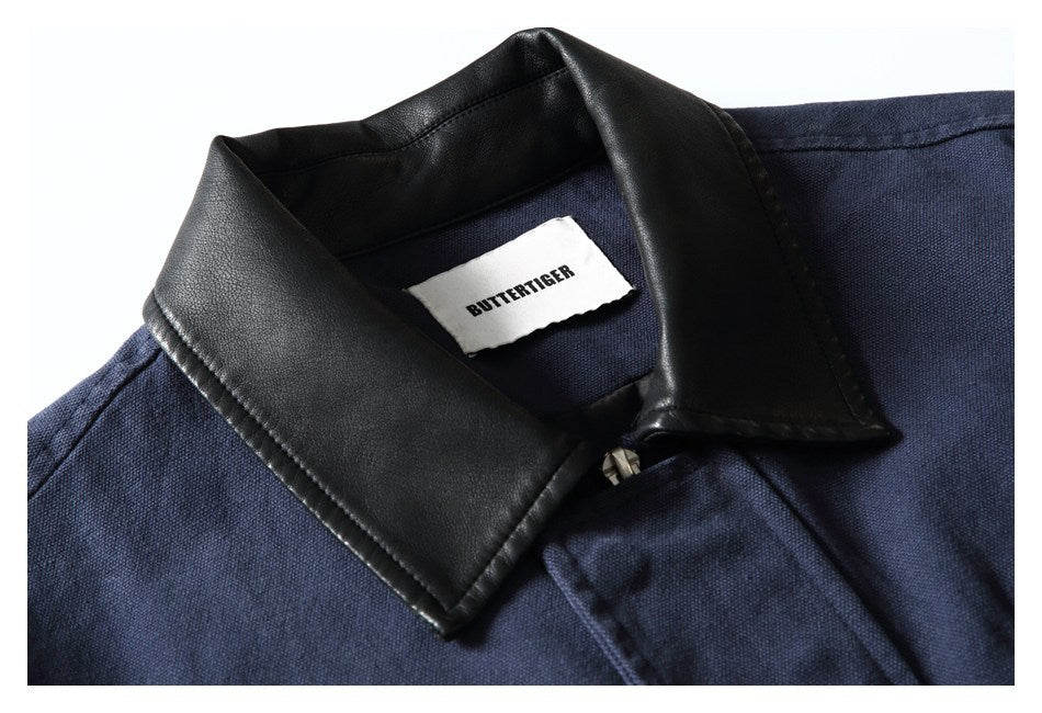 Close-up of a navy jacket's black textured collar, front zipper, and BUTTERTIGER neck label.