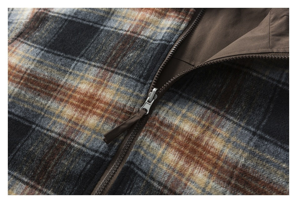 Close-up of the jacket's front zipper, silver pull, plaid exterior, and brown lining.
