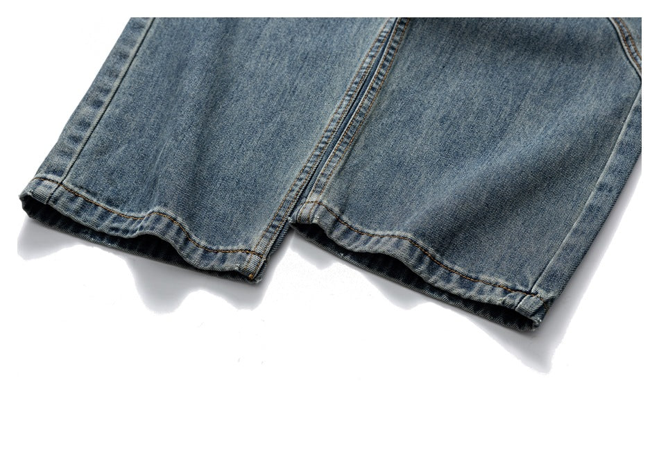 Close-up of the straight hems and seams on medium-wash blue jeans.