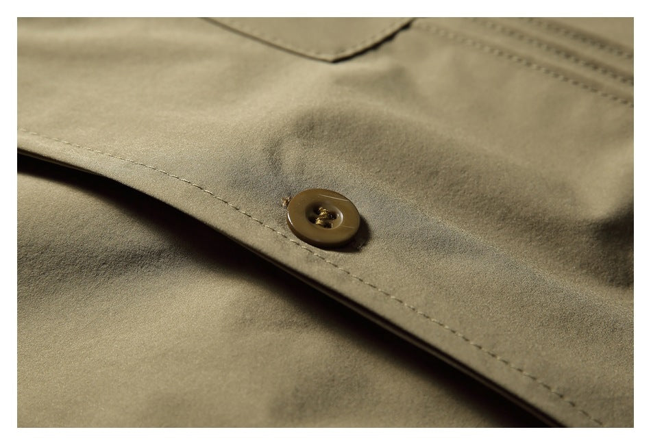 Extreme close-up of a brown button and stitching on the olive-khaki shirt front.