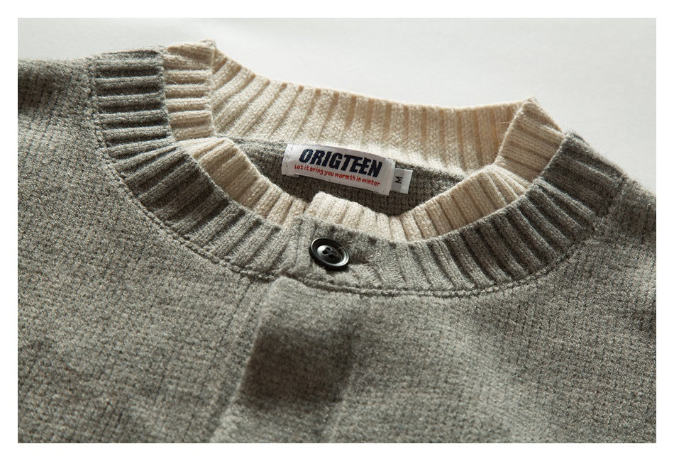 Close-up of the cardigan's gray knit neckline, cream ribbed collar, black button, and sewn-in label.