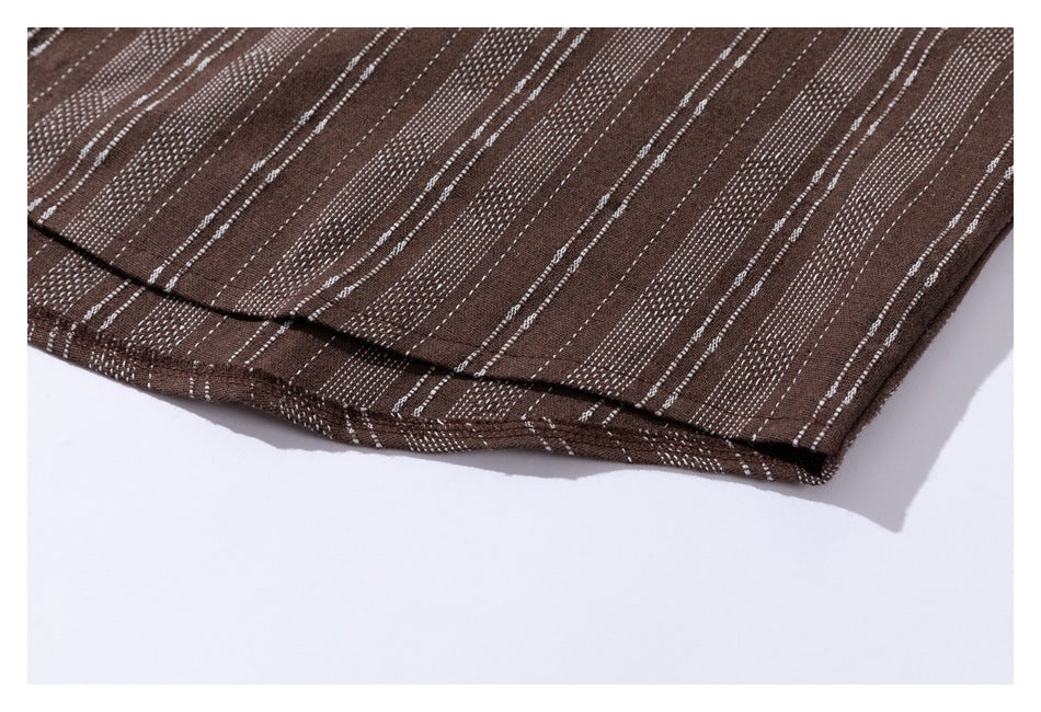 Close-up of the curved hem on brown fabric with narrow white stripes.