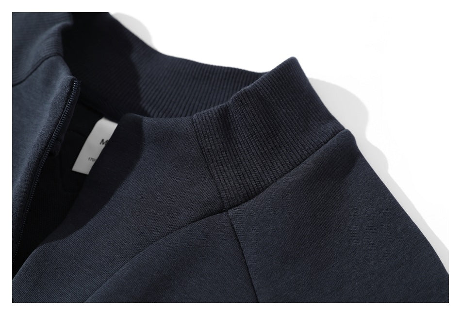 Close-up of the dark navy pullover's ribbed stand collar and partial front zipper.
