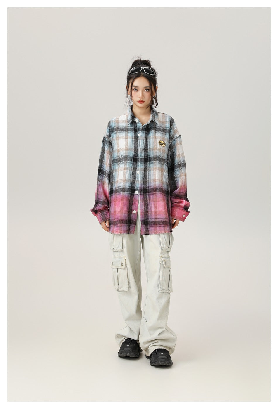 Model wearing the gradient plaid shirt buttoned with light cargo pants and black sneakers