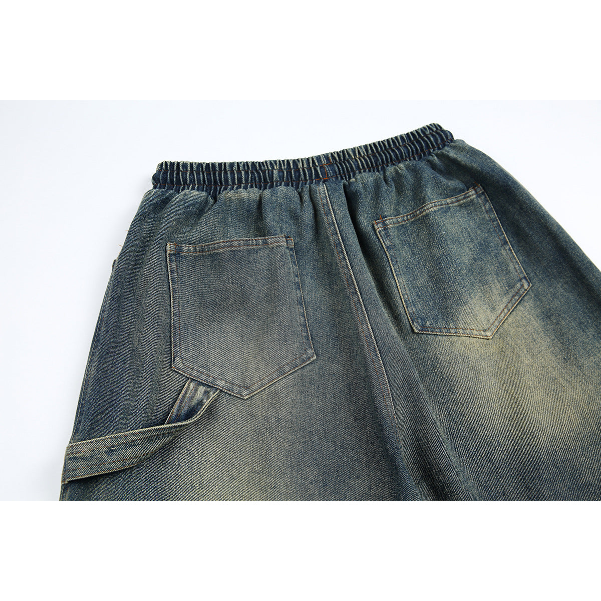 Close-up of the back of blue-gray denim shorts, showing two patch pockets and an elastic waistband.