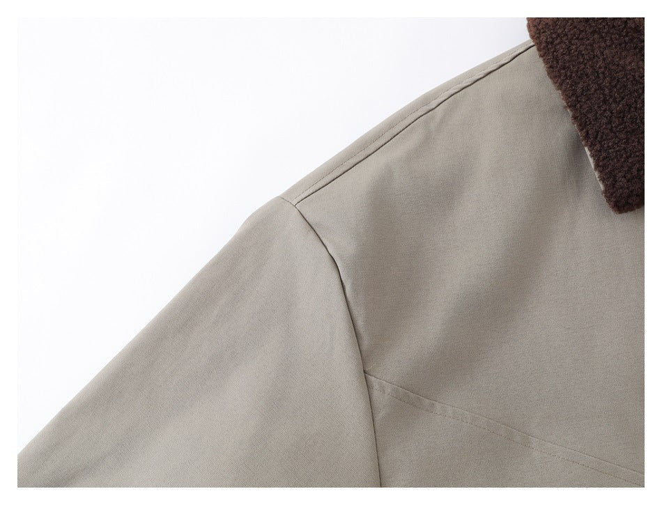Close-up of the taupe jacket's shoulder seam and dark brown collar edge.