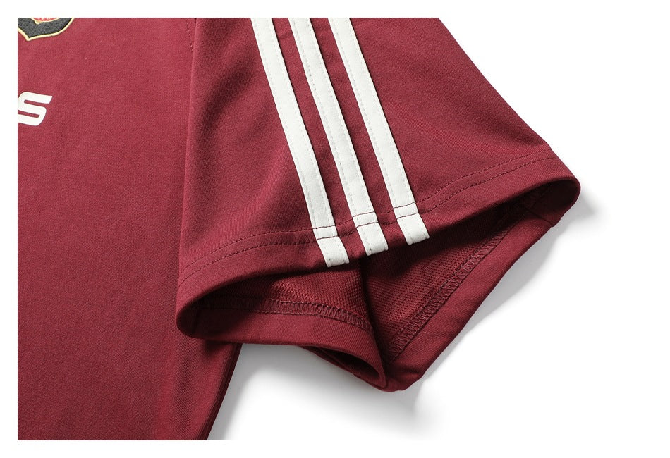 Close-up of the burgundy short sleeve with three white stripes and a stitched hem.