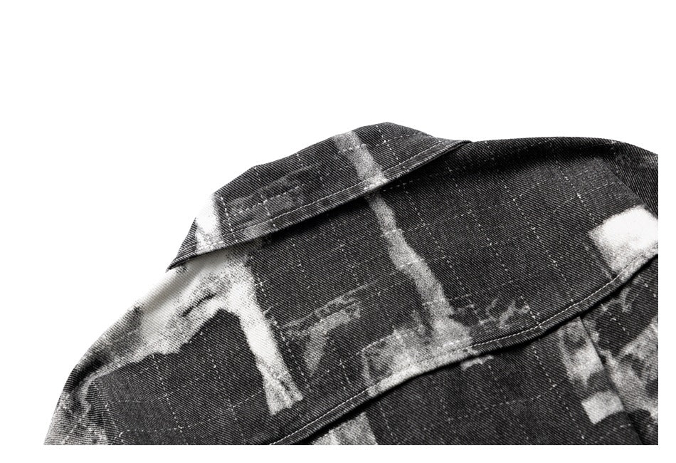 Close-up of the collar and shoulder seam on a black-and-gray abstract-print garment.