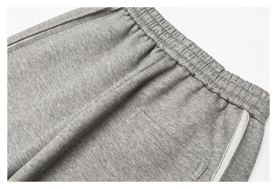 Close-up of gray heathered pants showing the gathered waistband and angled front pocket.