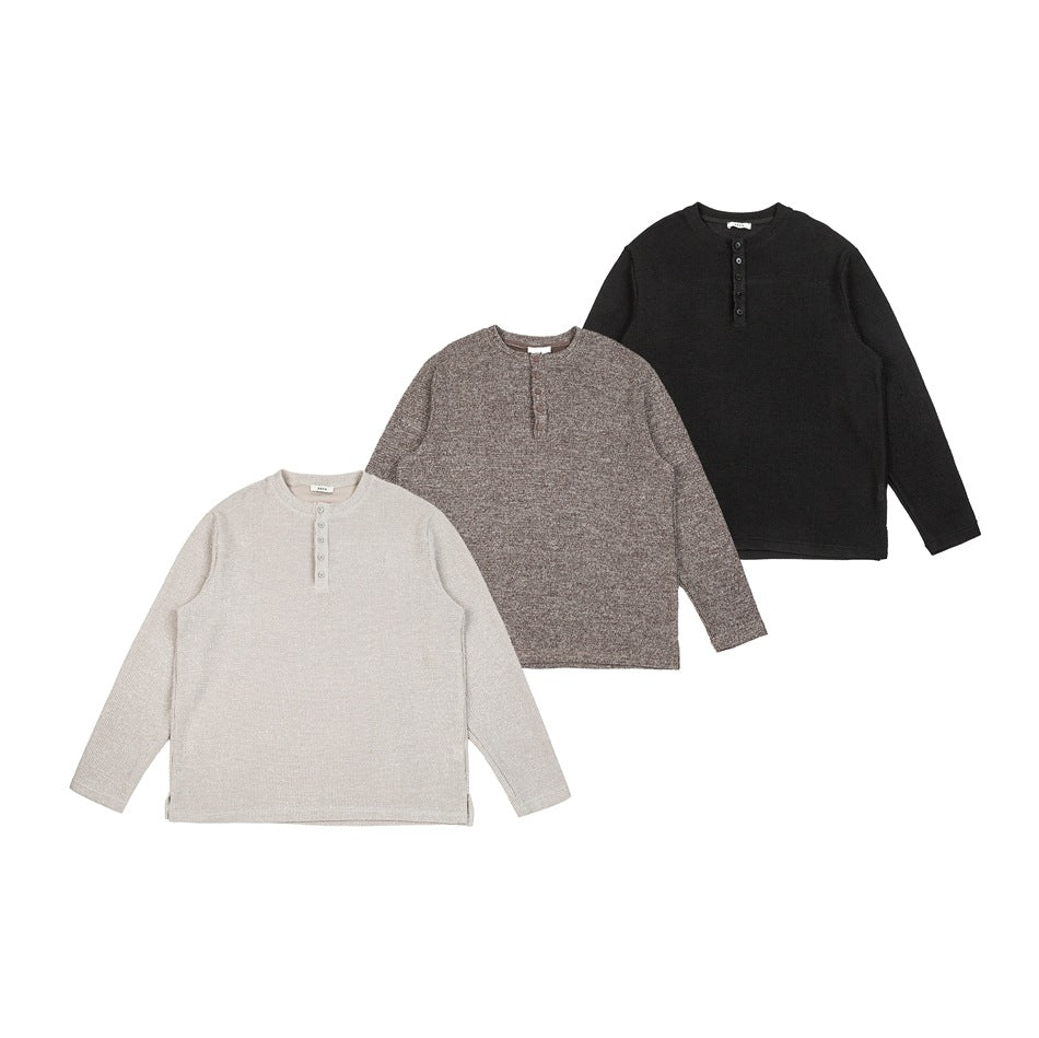 Three long-sleeve Henley tops laid flat in cream, heather brown, and black.