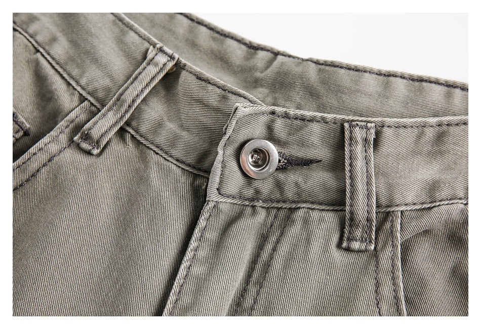 Close-up of the gray-olive trouser waistband, metal button, belt loop, and reinforced stitching.