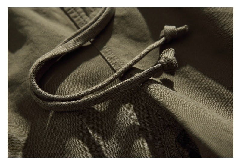 Close-up of an olive garment's matching drawstring and stitched fabric.