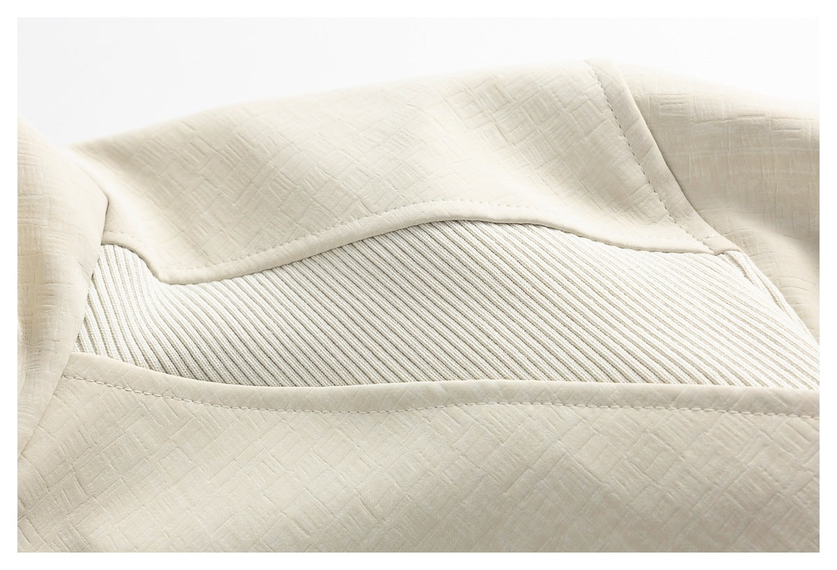 Close-up of an ivory jacket panel with a wide ribbed inset and stitched edges.