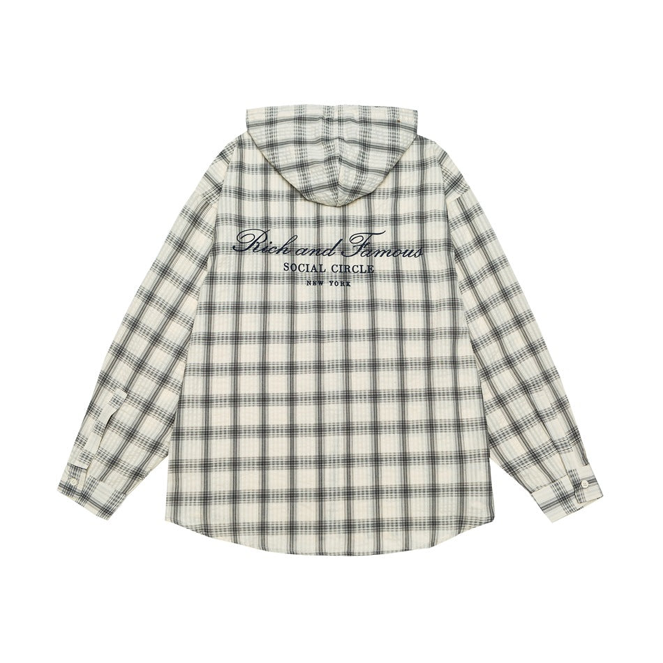 Back view of an ivory plaid hooded shirt with dark script embroidery across the upper back.