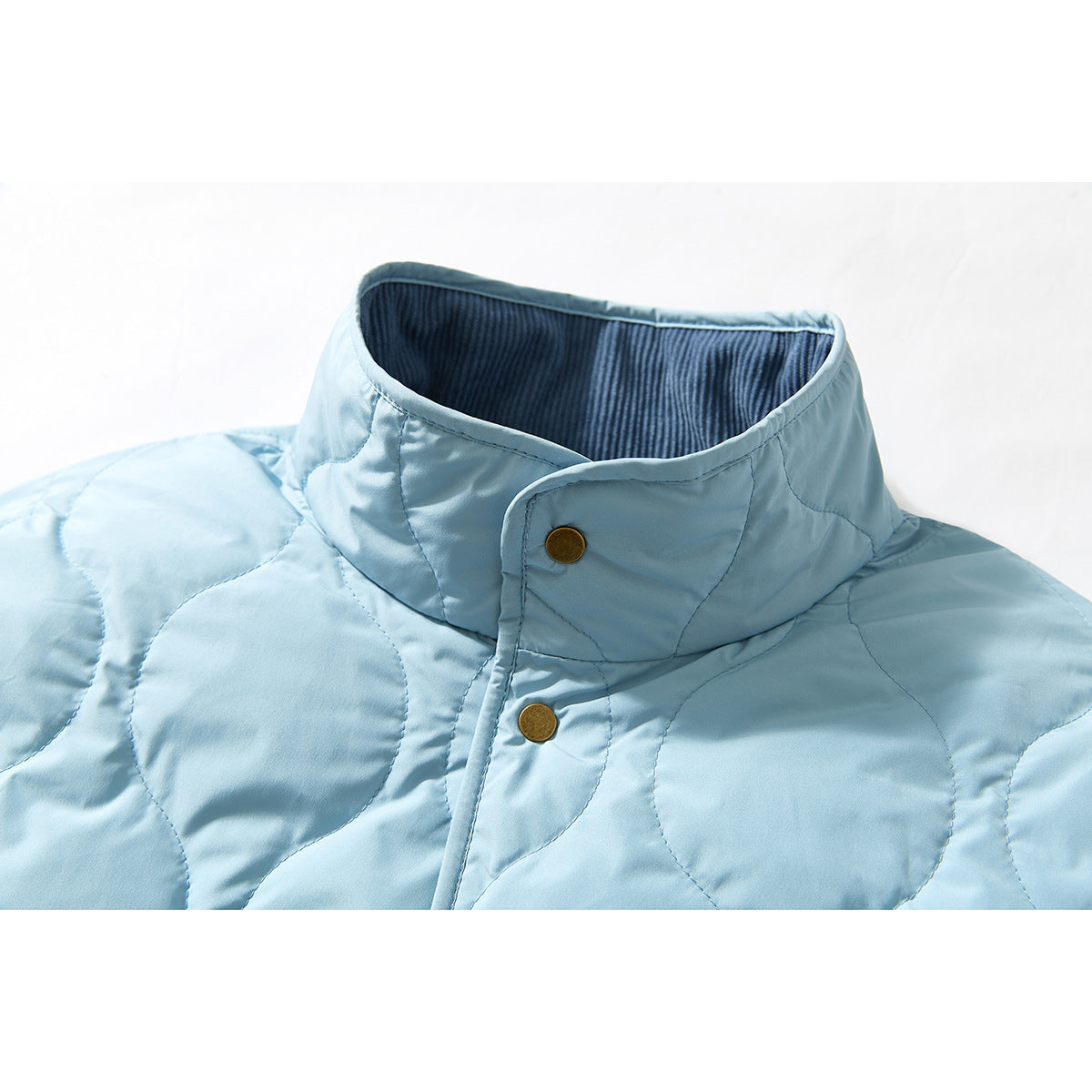 Close-up of a pale blue quilted jacket's high collar, dark ribbed lining, and brass snap buttons.