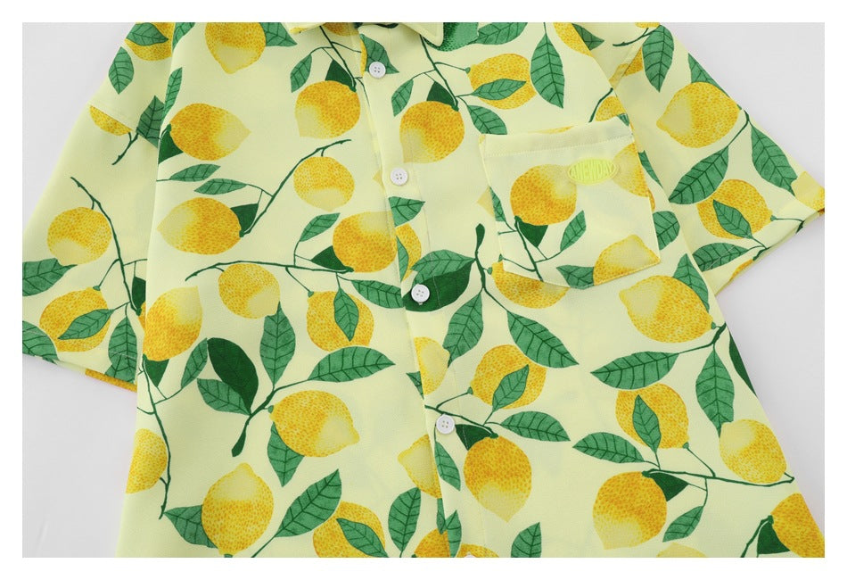 Close-up of the yellow lemon-print shirt front, showing its button placket and chest pocket.