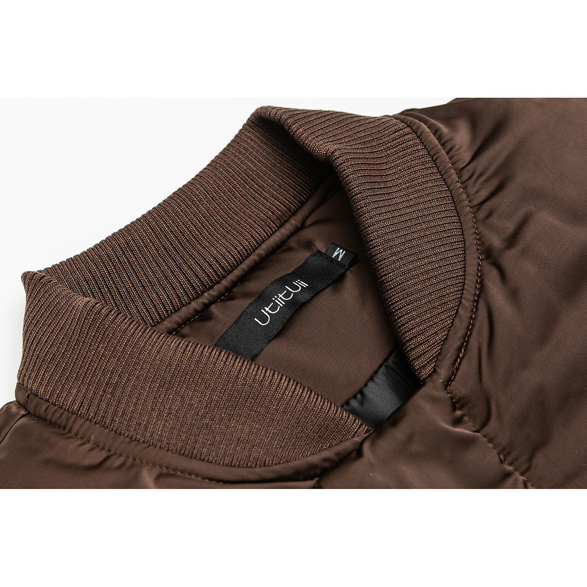 Close-up of a brown jacket's ribbed collar and sewn-in neck label.