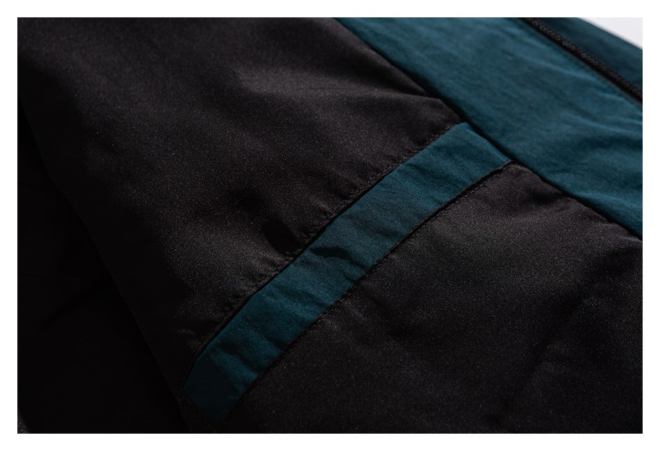 Close-up of black and dark teal garment panels with a contrasting teal strip and zipper edge.