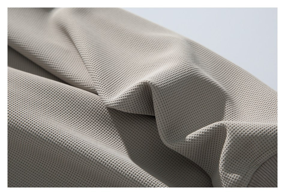 Close-up showing the draped waffle-knit texture of a taupe garment.
