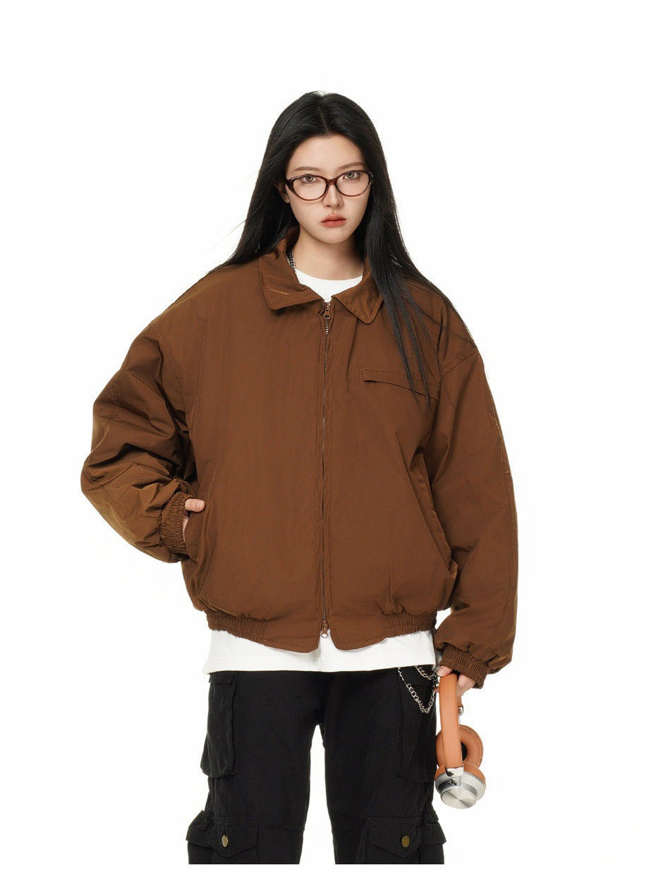 Model wearing a brown zip-front jacket with a pointed collar, chest pocket, roomy sleeves, and elastic hem.