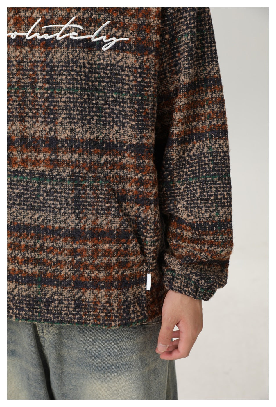 Close-up of the plaid pullover’s textured front, long sleeve, cuff, and hem.