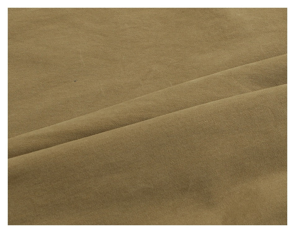 Close-up showing the fine diagonal weave and drape of khaki trouser fabric.