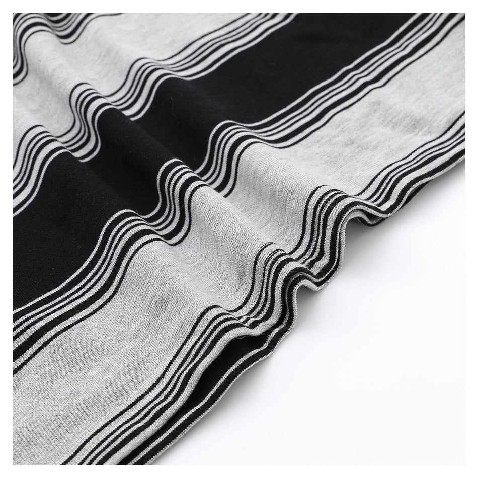 Close-up of draped black and heather-gray fabric with broad wavy stripes and narrow parallel lines.