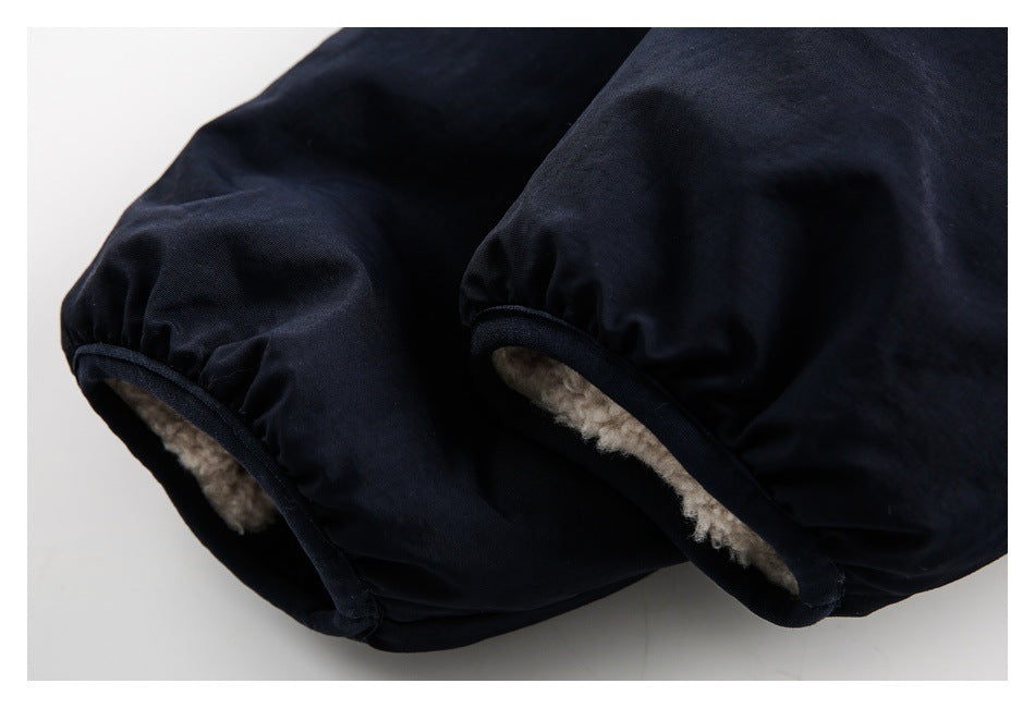 Close-up of black jacket sleeve openings with cream-colored fleece lining.