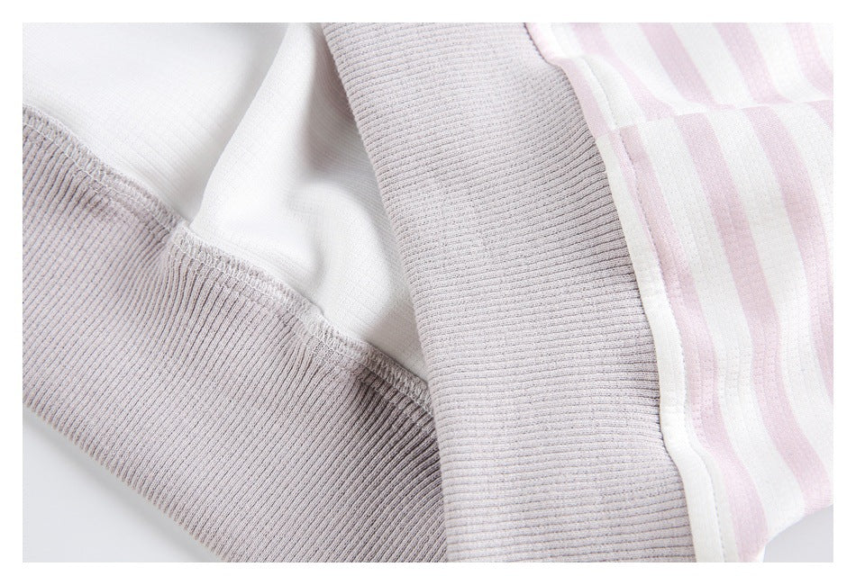 Close-up of a ribbed light gray cuff beside the striped garment fabric and inner seam.