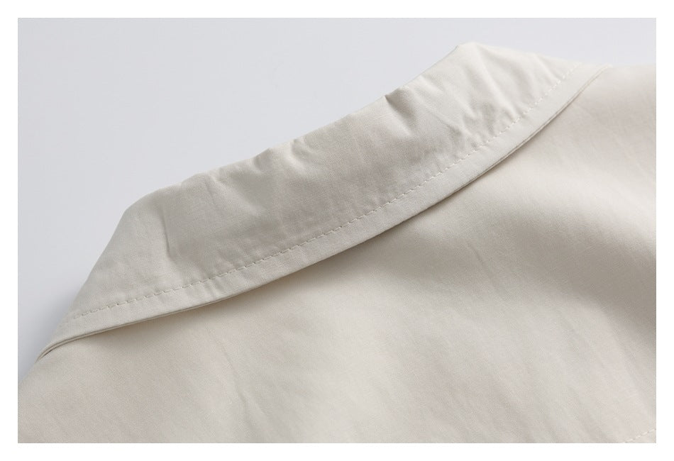 Close-up of an ivory garment collar with visible stitching.