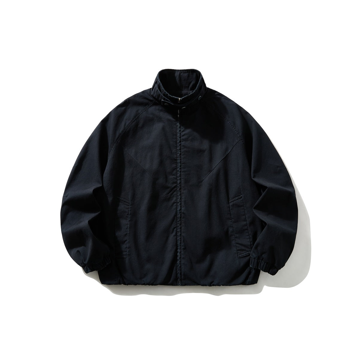 Navy zip-front stand-collar jacket flat lay with raglan sleeves, slanted pockets and elastic cuffs