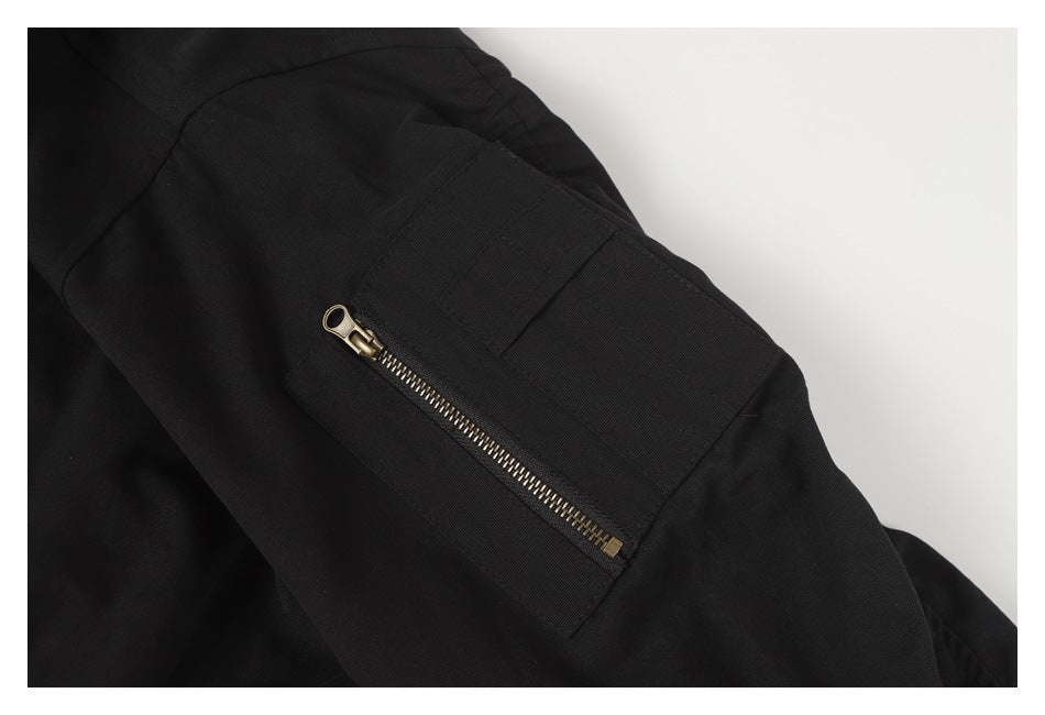 Close-up of a black sleeve pocket with a brass-tone zipper.