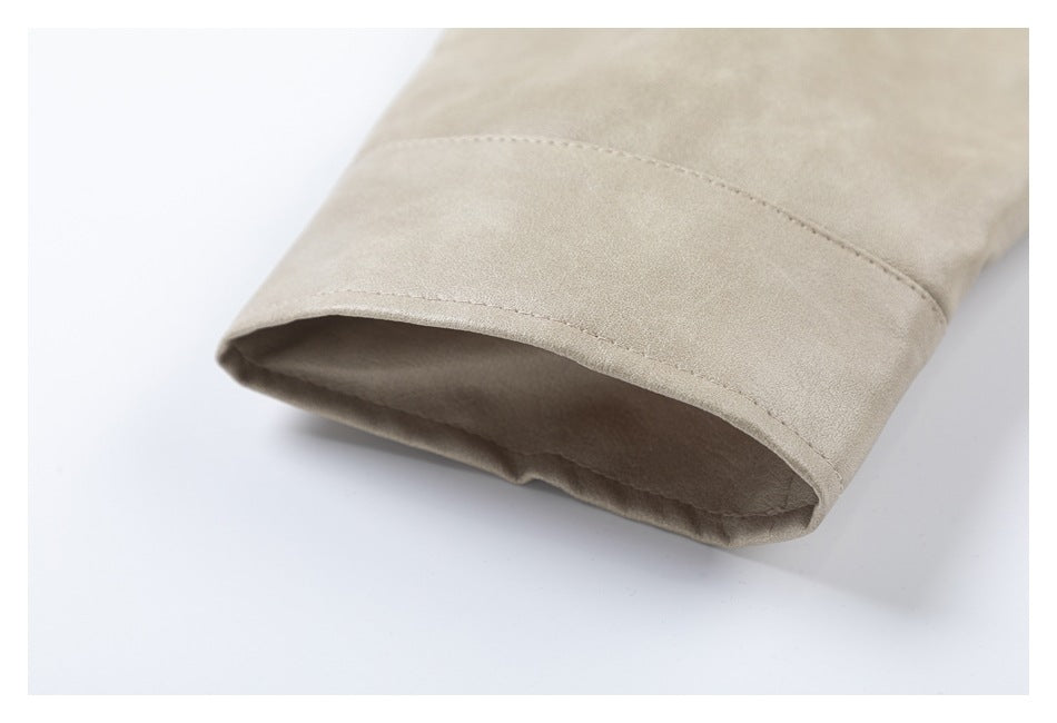 Close-up of the open sleeve cuff and curved seam on a light taupe coat.