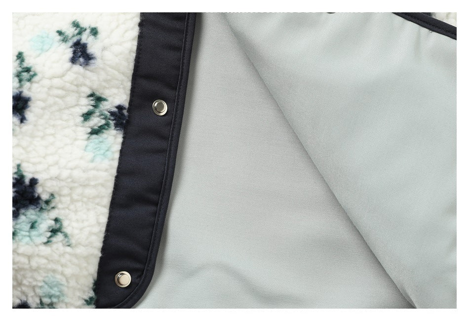 Close-up of the jacket's light gray lining, dark placket and metal snap fasteners.