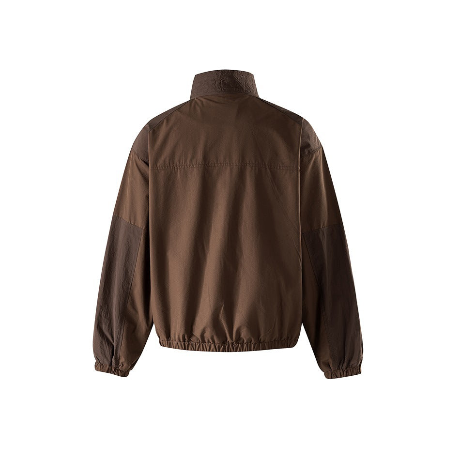 Back view of brown stand-collar jacket with yoke seam, darker sleeve panels and elastic hem on white background