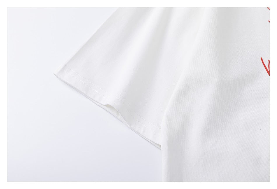 Close-up of the white T-shirt sleeve and its stitched hem, with a small portion of red print visible.