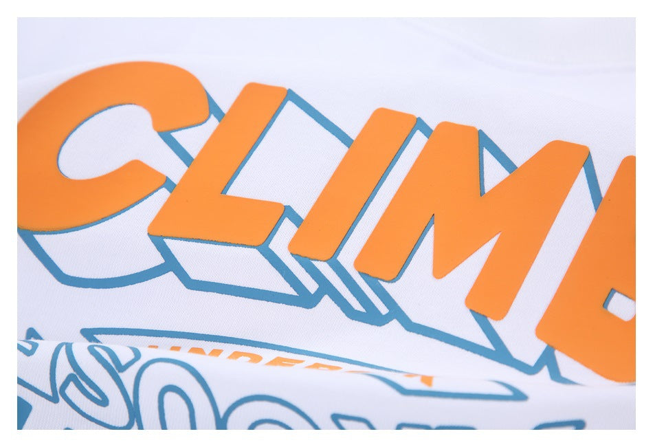 Close-up of the T-shirt's raised orange lettering with a blue outline on white fabric.