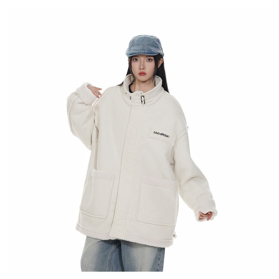 Model wearing the oversized beige stand-collar jacket with fleece-like trim and large patch pockets, with a denim cap and