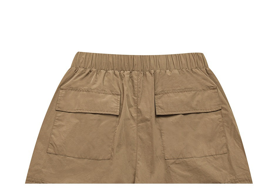 Back view of tan bottoms with an elastic waistband and two large flap pockets.