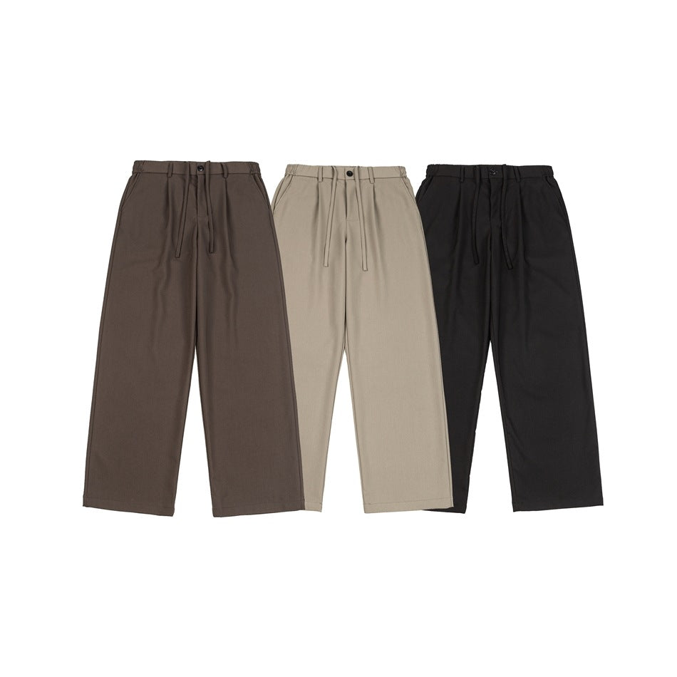 Three pairs of wide-leg trousers shown from the front in dark brown, taupe, and black.